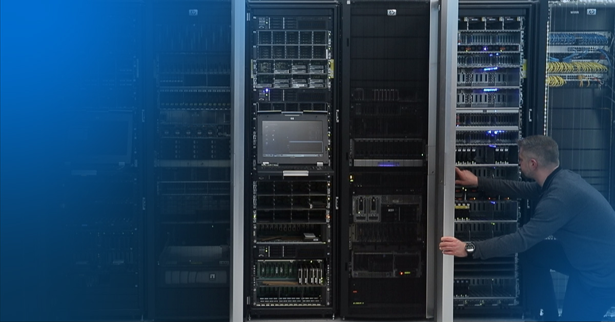 An image of an engineer knelt on one knee inspecting equipment in a data center