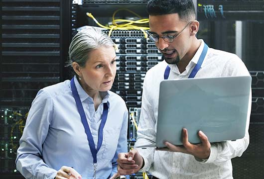 Two Engineers Collaborate in Server Room