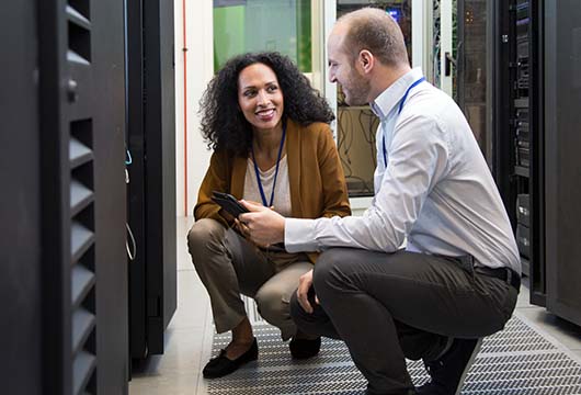 Two Engineers Kneel by Servers