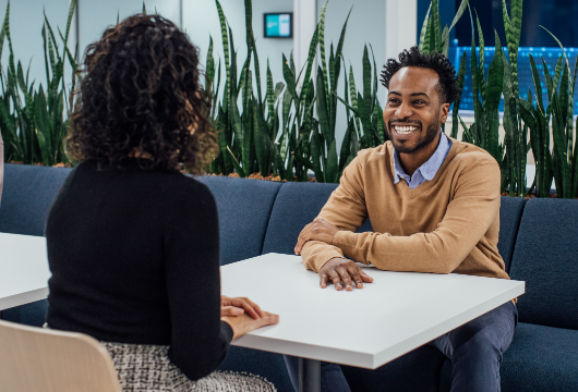 An image of coworkers conversing and smiling at a table